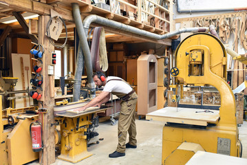 Tischler arbeitet an einer Kreissäge in der Werkstatt // carpenter works in a joinery - workshop...