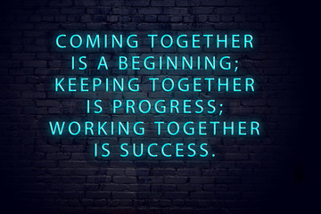 Positive inspiring quote on neon sign against brick wall 