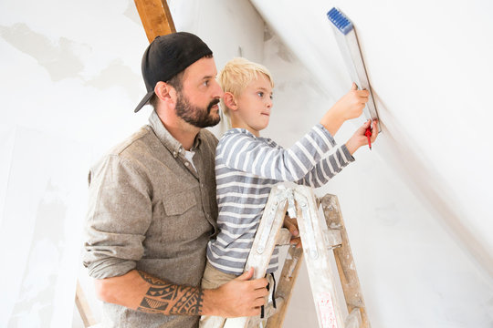 Father and son working on loft conversion using water level