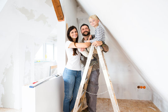 Portrait of happy family working on loft conversion