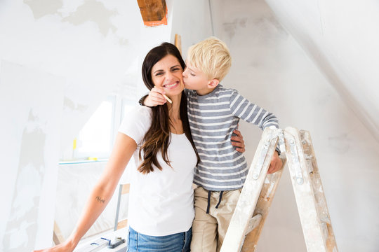 Portrait of happy mother and son working on loft conversion