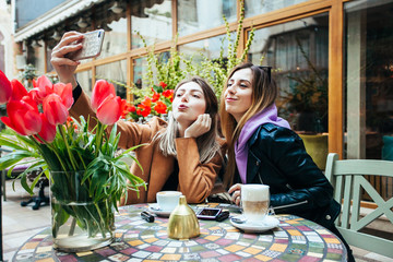 Beautiful girls making selfie in a Parisian cafe