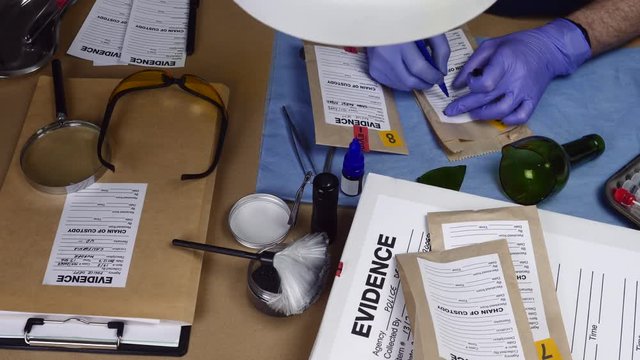 Police expert filled form with evidence bag in crime lab