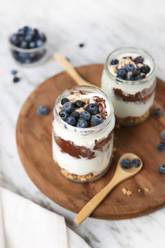 Chia pudding parfait with chocolate and yoghurt with blueberries and granola in jars