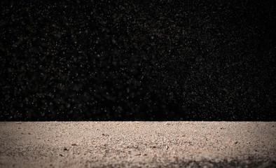 fine dust pours on the table on a black background