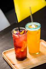 Fresh lemonade with straws with fresh strawberry and orange on a bar table.