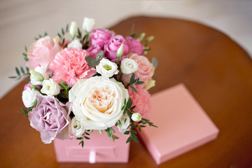 Square pink flower box with a secret department with a tile of home-made natural chocolate with fresh rose, chrysanthemum, peony-shaped rose
