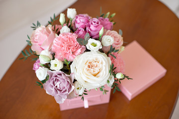 Square pink flower box with a secret department with a tile of home-made natural chocolate with fresh rose, chrysanthemum, peony-shaped rose