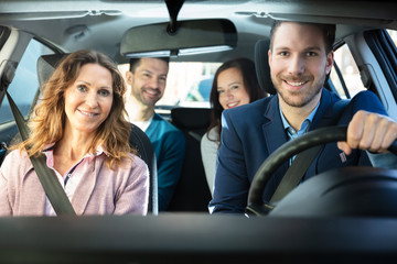Fototapeta na wymiar Smiling People Sitting In Car
