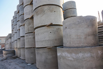 Concrete ring wells with different diameters and gray lie in the street