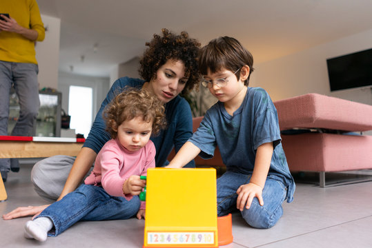 Mother playing and children playing with a toy till