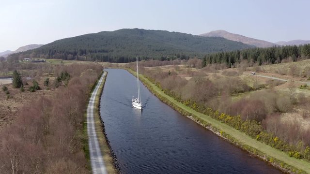 A Luxury Sailing Yacht Motoring Along a Canal