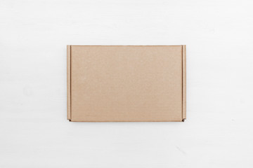 Blank cardboard parcel box on a white table background.