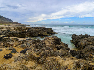 Fototapeta na wymiar Coastline at the west side of Oahu, Hawaii with large rocks at the beach.