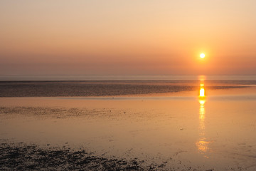Stunning sunrise on Wadden island Texel Netherlands. Sun going up over the muflats of the Wadden Sea