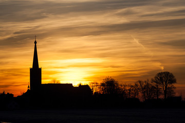 Fototapeta na wymiar Silhouette of the church of Stompwijk at sunset (Netherlands)
