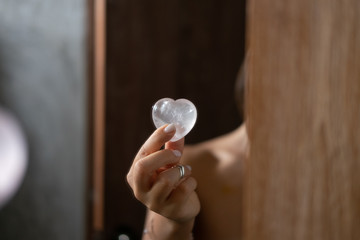 Woman holds rose quartz heart crystal