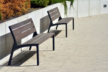 Two wooden benches on cement floor at park