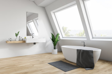 Attic white bathroom corner, tub and sink