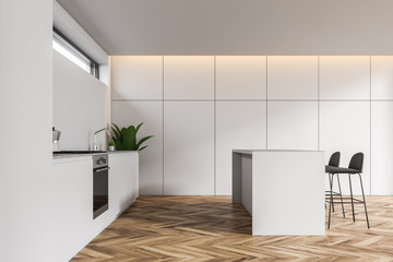 Side view of white kitchen with bar and counters