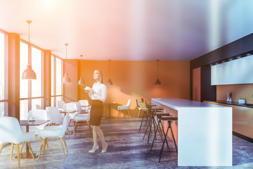 Young woman with coffee in orange restaurant
