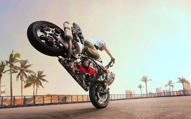 Moto rider making a stunt on his motorbike. Biker doing a difficult and dangerous stunt.