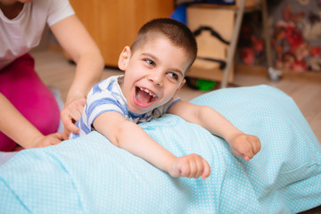 little kid with cerebral palsy has musculoskeletal therapy by doing exercises in body fixing. Load...
