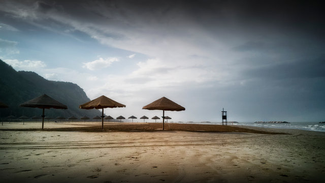 Ombrelloni di paglia sulla spiaggia pronti per la stagione estiva a Pesaro nella regione Marche in Italia © cristian