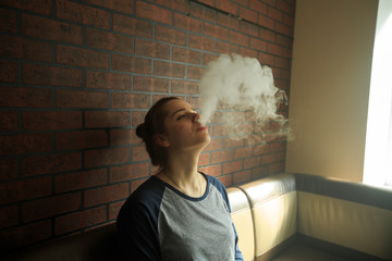Vape teenager with  problem skin. Portrait of young cute girl smoking an electronic cigarette in...