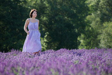 Young woman relaxing in blooming lavender field
