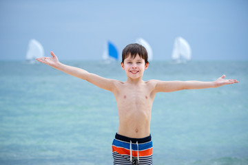 Cute seven years old boy having fun on tropical beach