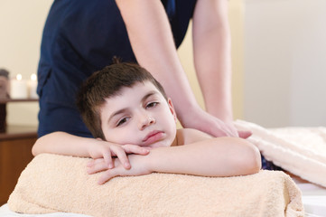 Obraz na płótnie Canvas Relaxed little boy on reception at the chiropractor. Wellness massage procedure