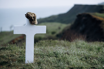 military cap on the grave cross