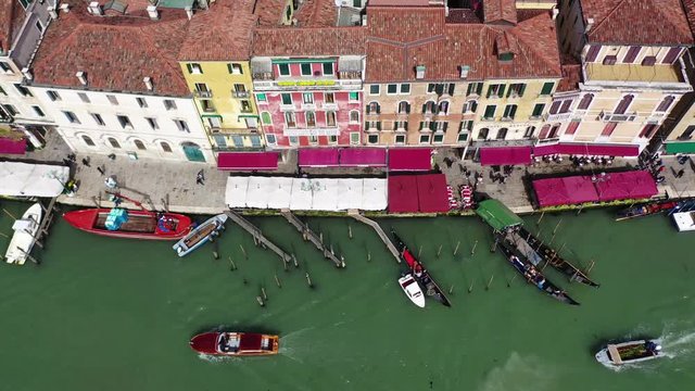 Aerial drone top view video of iconic and unique colourful Gondolas in Grand Canal near Rialto bridge, Venice, Italy