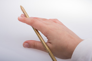 Hand holding a gold color pencil  in hand