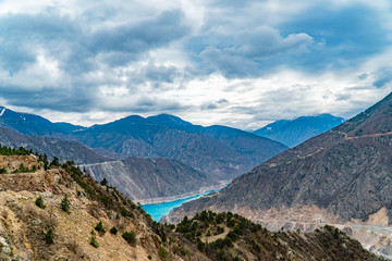 The fantastic view of river with mountains under a blue sky with clouds.