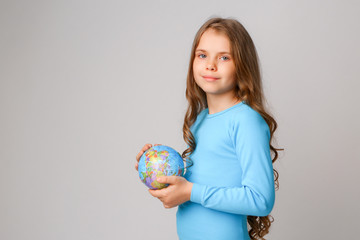 baby girl in blue dress holding globe, concept of environmental protection 