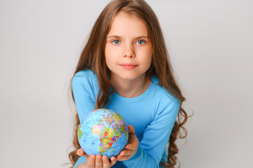 baby girl in blue dress holding globe, concept of environmental protection 
