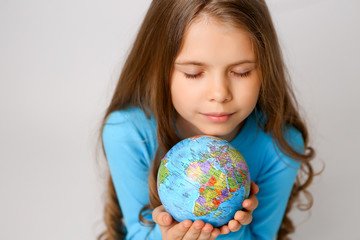 baby girl in blue dress holding globe, concept of environmental protection 