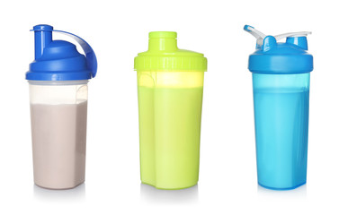 Set of sport bottles with delicious protein shakes on white background