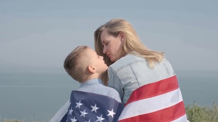 young woman with her son holding an american flag - Powered by Adobe