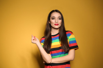 Portrait of beautiful young woman on colorful background