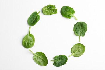 Frame made of spinach leaves on white background, top view. Space for text