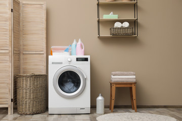 Modern washing machine near color wall in laundry room interior, space for text - obrazy, fototapety, plakaty