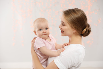 Portrait of happy mother with her baby against blurred lights