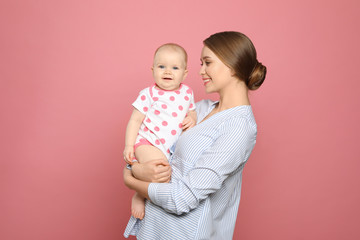 Portrait of happy mother with her baby on color background
