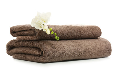 Fototapeta na wymiar Clean folded towels with flowers on white background