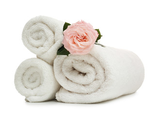 Obraz na płótnie Canvas Clean rolled towels with flower on white background