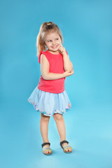 Full length portrait of cute little girl against color background