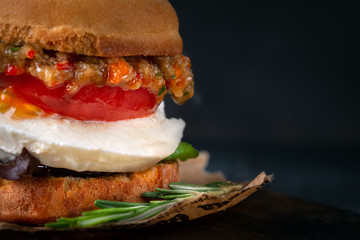 Vegetarian Burger made from fried eggplant, tomato, lettuce, avocado and mozzarella cheese on a...